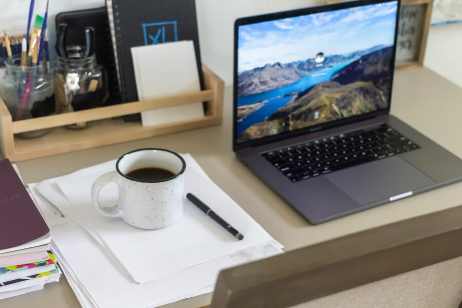 Coworkers office desk laptops coffee