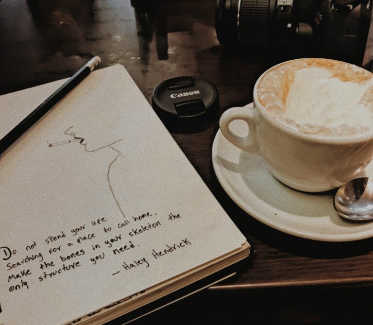 Close handwritten song lyrics notebook acoustic guitar coffee