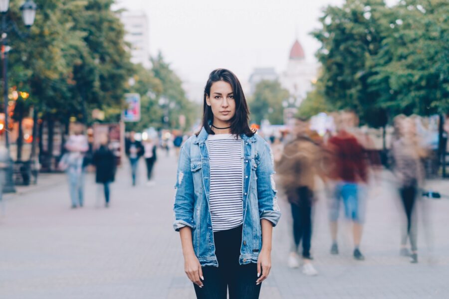 Woman walking city street casual jeans blazer sneakers