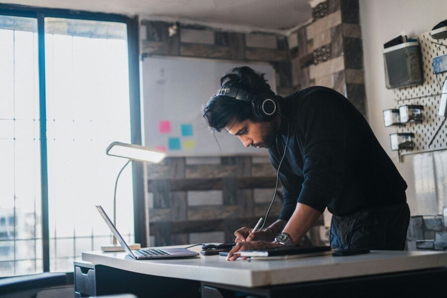 Person studying desk headphones soft light