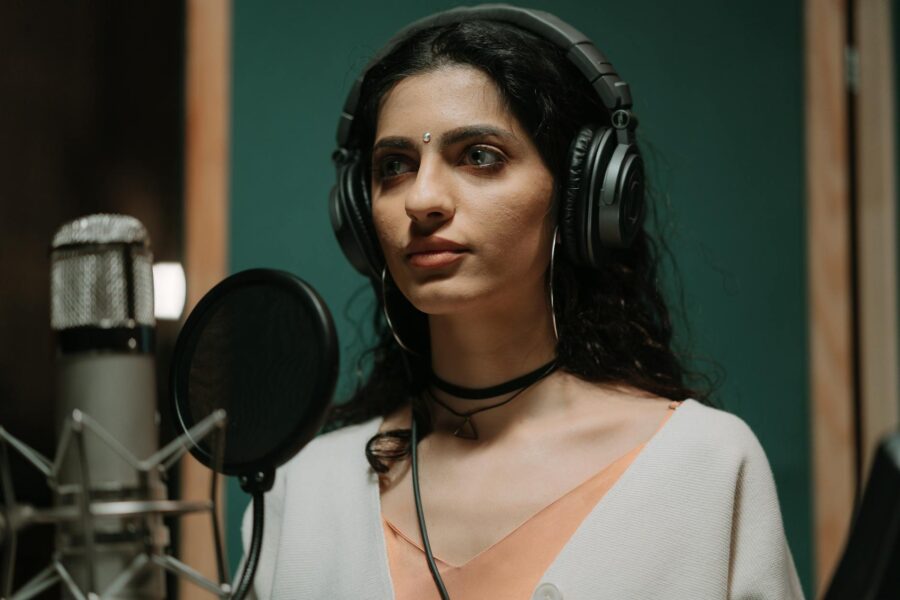 Singer recording vocals home studio microphone headphones